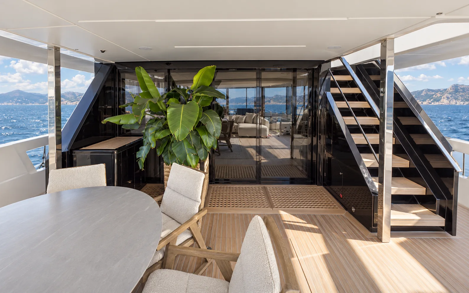 Aft deck table and the stair to the upper deck, with the saloon beyond