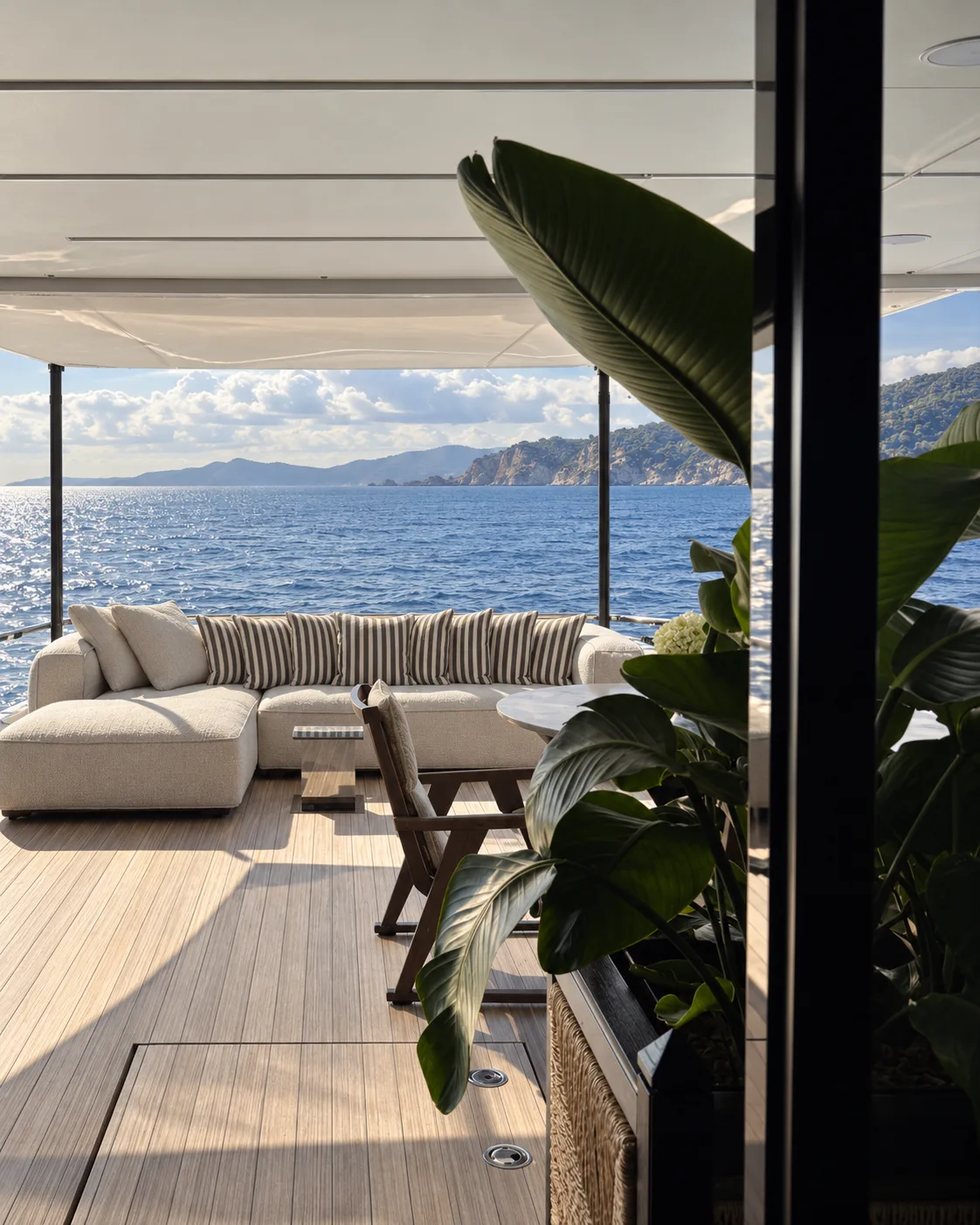 Aft deck sofa beside a planter, with the sea beyond