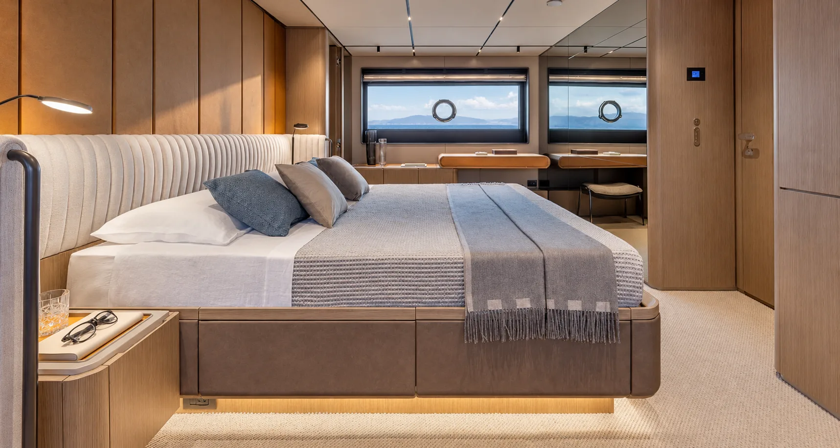 Owner’s suite with hull windows behind the bed
